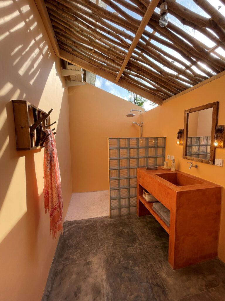 FabuLous Place Lombok surf villa orange bathroom with open air shower and handmade wooden mirror and hanger and industrial mirror lights